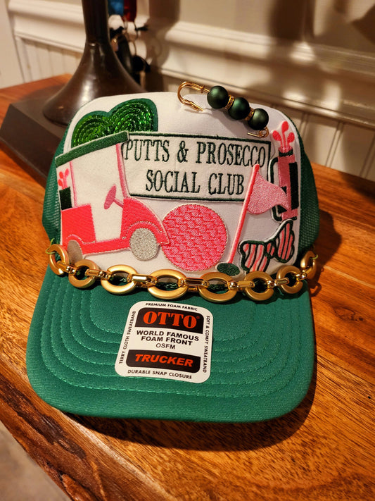 Putts and Prosecco Social Club Trucker hat with golf themed patches in pink and green.