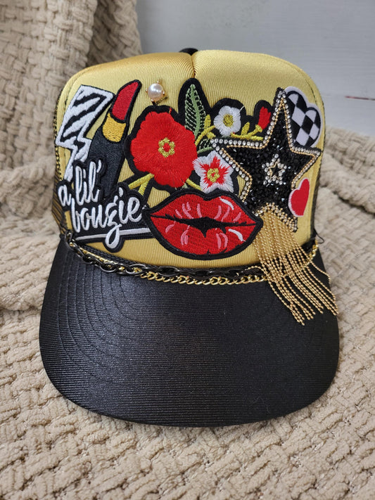 Lil' Boujie foam snapback trucker hat with red and gold accesories.