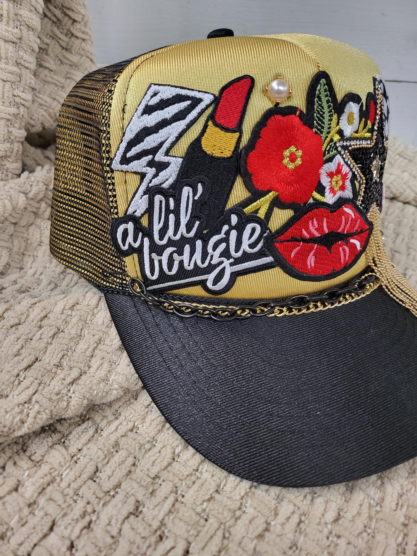 Lil' Boujie foam snapback trucker hat with red and gold accesories.